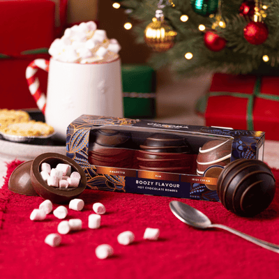 Boozy Hot Chocolate Bombs with Marshmallows in a Christmas setting