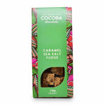 A package of Cocoba Chocolate Caramel Sea Salt Fudge, featuring a bright green box with colorful patterned borders and a clear window showing the fudge pieces inside.
