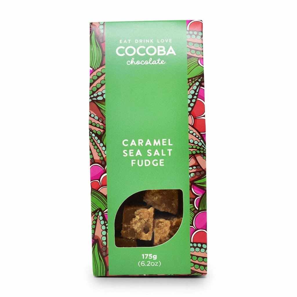 A package of Cocoba Chocolate Caramel Sea Salt Fudge, featuring a bright green box with colorful patterned borders and a clear window showing the fudge pieces inside.