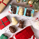 Hot chocolate bombs with marshmallows in a decorative box on a festive background with Christmas decorations.