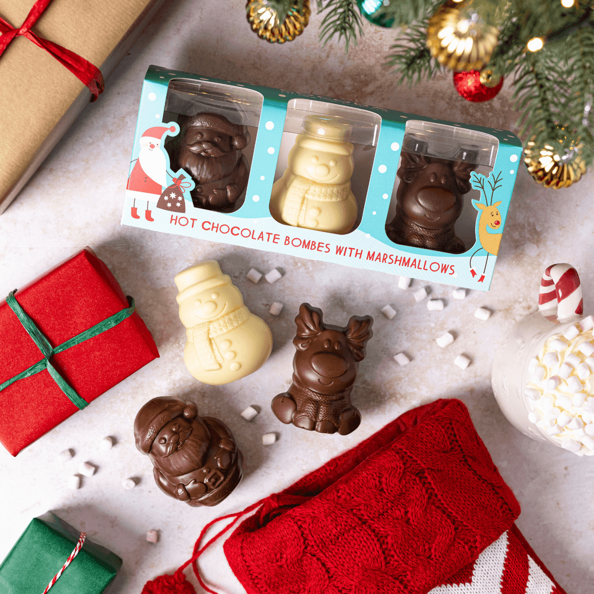 Hot chocolate bombs with marshmallows in a decorative box on a festive background with Christmas decorations.
