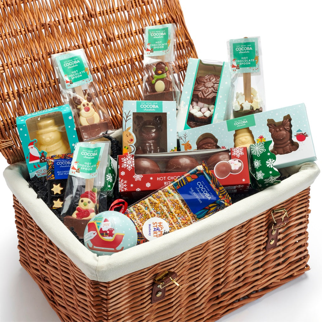 A wicker gift basket filled with a multitude of Christmas chocolates and hot chocolates. 