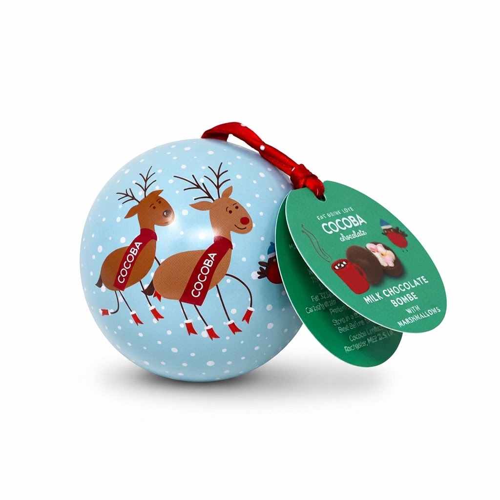 A round blue Christmas ornament decorated with two brown cocoa-reindeer wearing red scarves that read 'COCOPA', hanging from a red ribbon with a green product tag attached. The tag reads 'MILCH CHOCOLATE SPREE' and 'COCOPA' is visible on the ornaments.