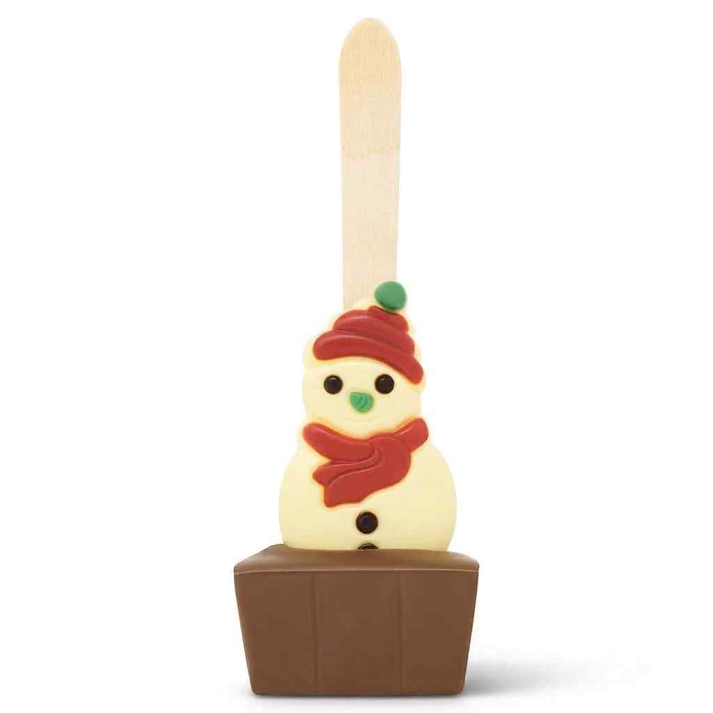 A novelty chocolate hot cocoa stick in the shape of a snowman wearing a red hat and scarf, set in a hot chocolate base on a white background.