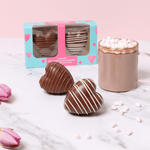 Heart Shaped Hot Chocolate Bombes with Marshmallows out of box with a hot chocolate. 