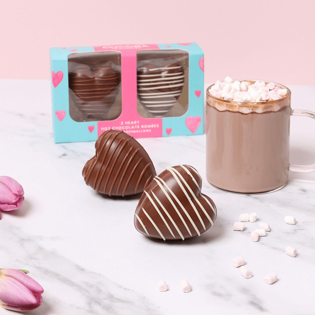 Heart Shaped Hot Chocolate Bombes with Marshmallows out of box with a hot chocolate. 