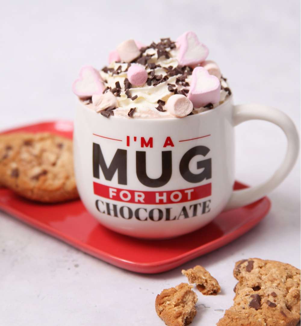 A Cocoba Hot Chocolate Mug with a hot chocolate, and cookies