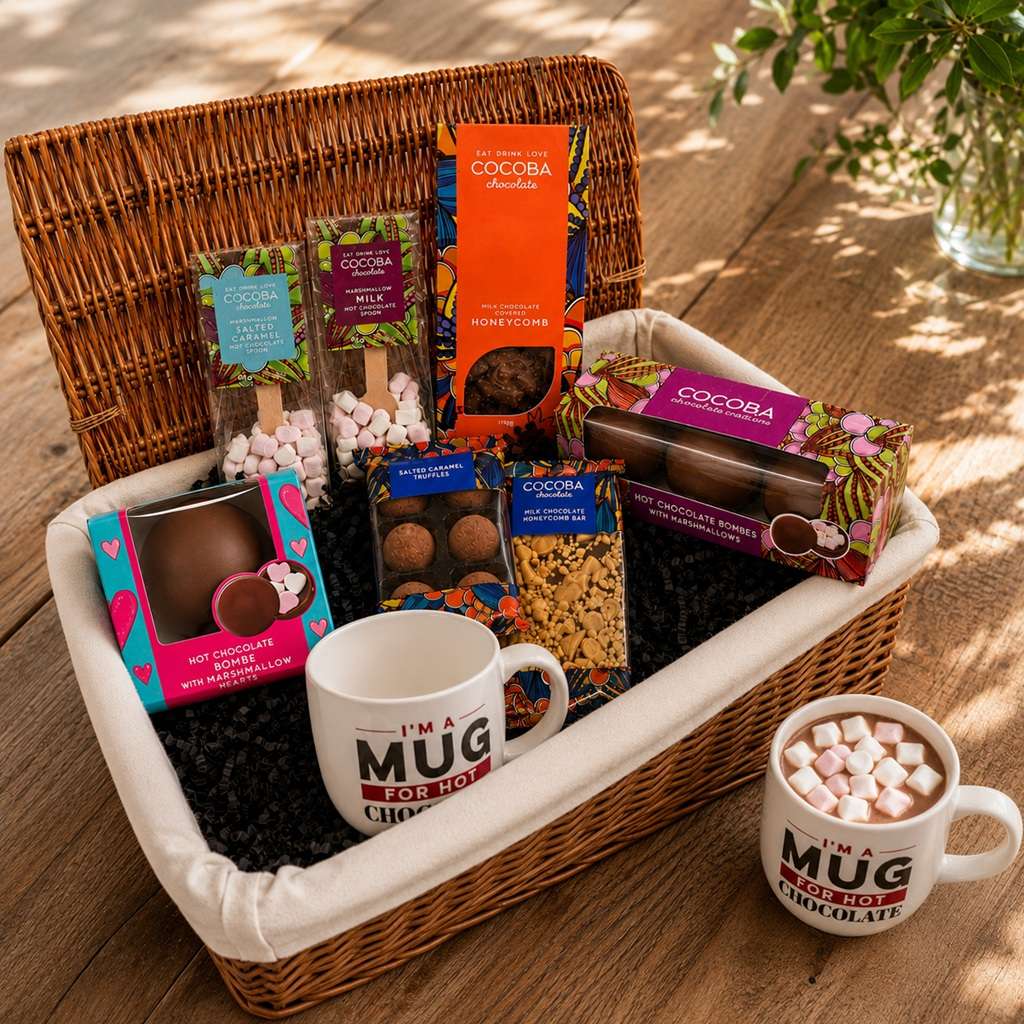 Luxury wicker basket filled with 2 Cocobe mugs, Cocoba Hot Chocolate Bombes, hot chocolate spoons, truffles, chocolate covered honeycomb and a chocolate bar.