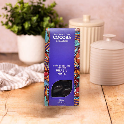 Cocoba chocolate packaging on a wooden surface with decorative items in the background