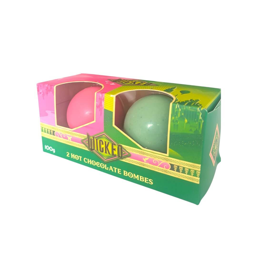 Green and pink hot chocolate bombs in a green box on a white background