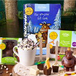 Gruffalo Hot chocolate set with cocoa bombs, spoons, and a mug on a wooden surface.