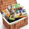 Wicker gift basket with assorted treats and snacks on a white background