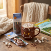 Hot chocolate with marshmallows in a Gruffalo-themed mug on a wooden table.