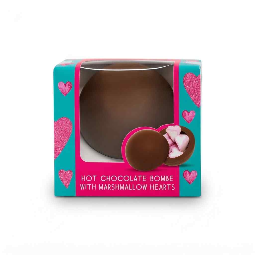 A boxed hot chocolate bomb with marshmallow hearts. The product is shown in its retail packaging, which features a turquoise and pink design with heart graphics and a clear window displaying the chocolate bomb inside.