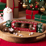 Christmas Cracker Hot Chocolate Bombes with Marshmallows in a Christmas setting