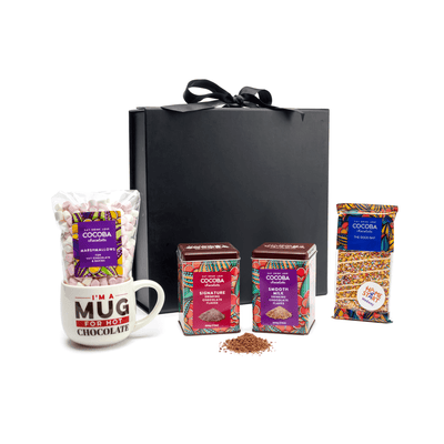 Cocoba chocolate products including a mug, Cocoba Hot Chocolate Flakes, and marshmallows on a white background