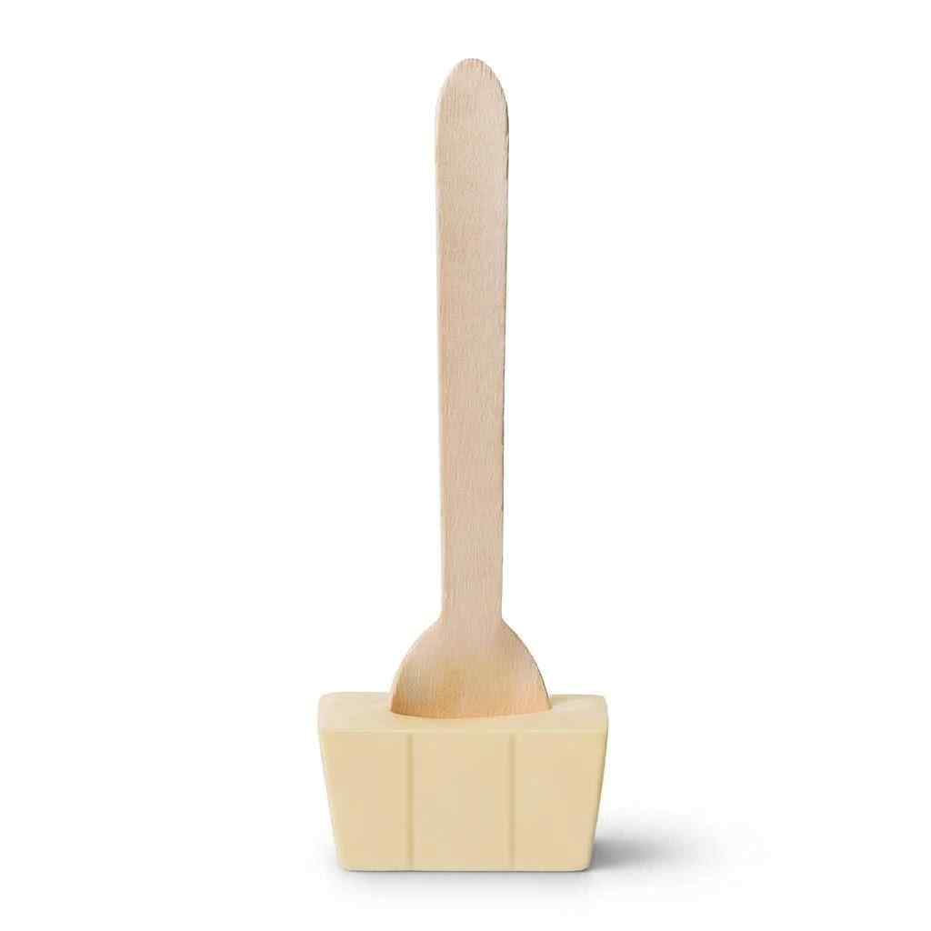 A  wooden spoon with a white chocolate block base, shown on a plain white background.