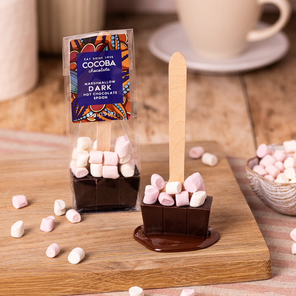 Dark chocolate hot chocolate spoon with mini marshmallows, on a wooden table