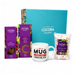 Cocoba Chocolate gift set featuring a turquoise gift box, milk chocolate buttons, 35% smooth milk chocolate flakes, a bag of marshmallows, and a white ceramic mug that reads 'I'M A MUG FOR HOT CHOCOLATE'.