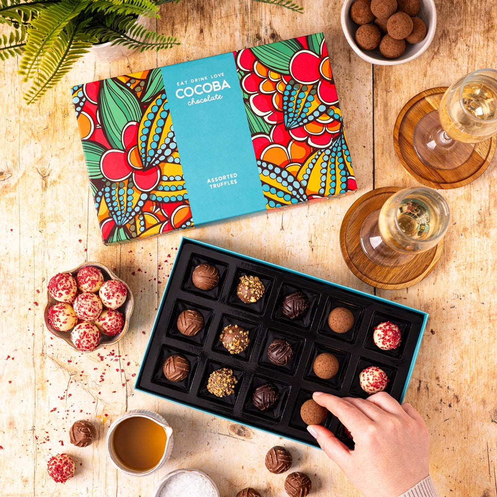 A beautifully presented Box of Cocoba assorted chocolate truffles on a wooden table.