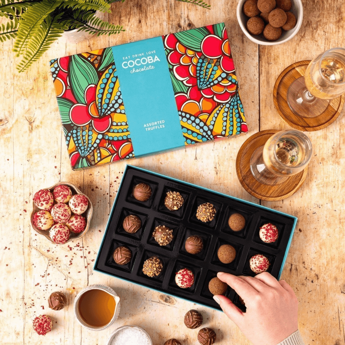 A beautifully presented Box of Cocoba assorted chocolate truffles on a wooden table.