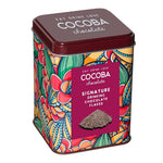 Colorful tin of Cocoba chocolate with decorative design and label.