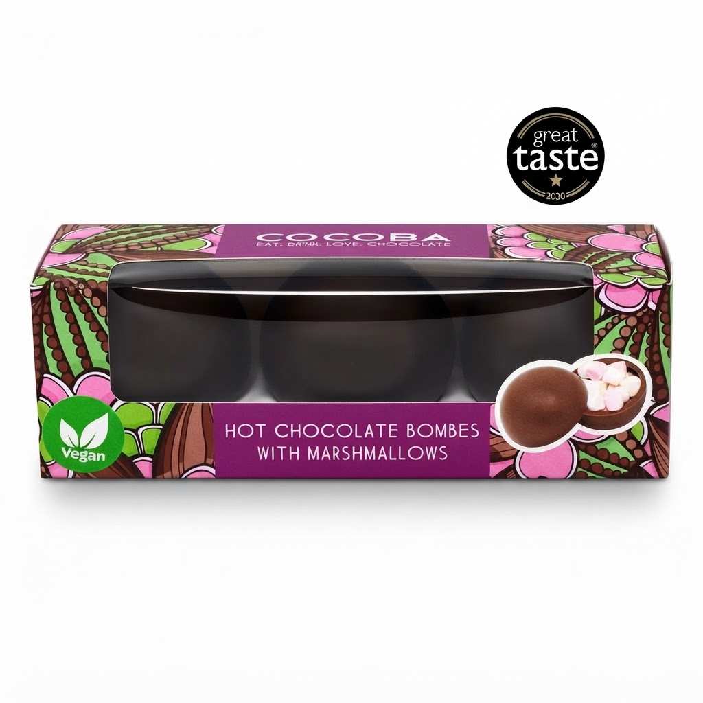 Cocoba vegan hot chocolate bombs with marshmallows in a rectangular box with a clear window, featuring a purple label and colorful chocolate-themed illustrations. A black 'great taste 2020' award badge is shown in the top right corner.