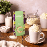 White Drinking Chocolate Flakes on a wooden table with a White hot chocolate. 