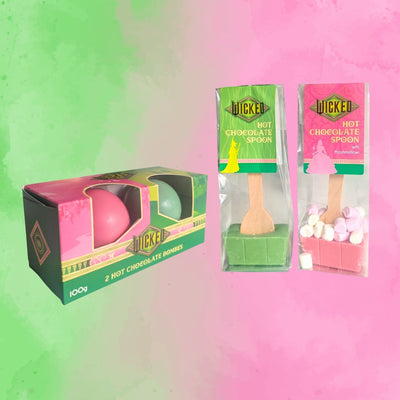 Wicked hot chocolate products including a pink and green hot chocolate bombes, and hot chocolate wooden spoons with marshmallows on a Wicked background.