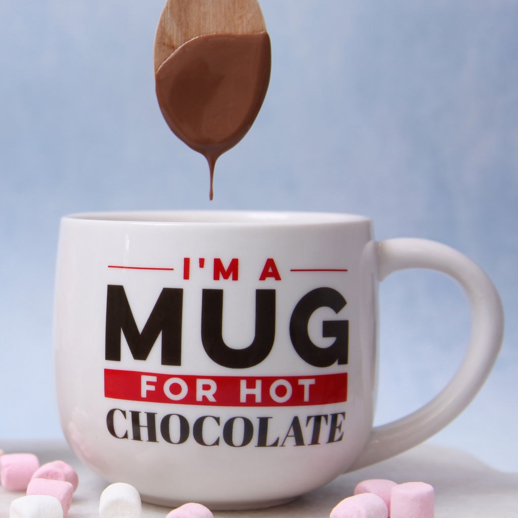 Milk Hot Chocolate Spoon dripping into a Cocoba Hot Chocolate Mug which says 'I'm a Mug for Hot Chocolate' on it.